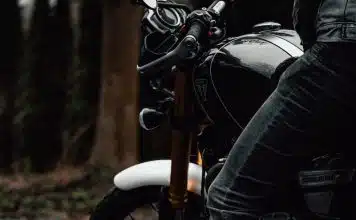 person in black jacket and blue denim jeans riding on motorcycle